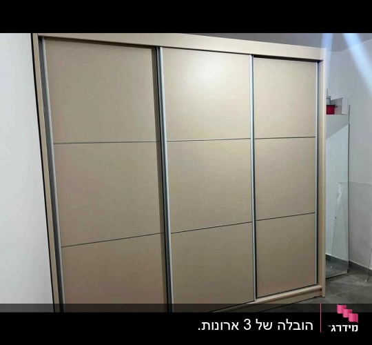 ארון הזזה גדול בעל שלוש דלתות העומד בחדר